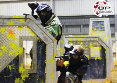 Two Friends Playing Paintball Indoors